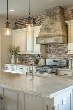 a kitchen with an island and brick wall