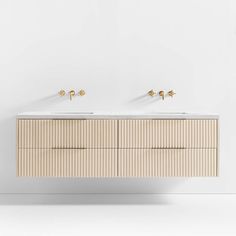 two white sinks sitting next to each other on top of a wooden cabinet with gold handles