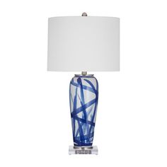 a blue and white table lamp with a white shade on the top, against a white background