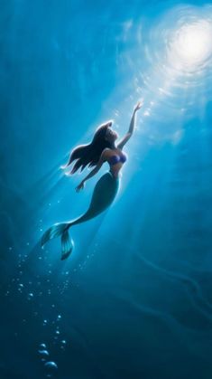 a woman is swimming in the ocean with her arms outstretched and head above water's surface