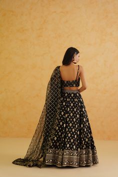 Black Brocade Lehenga Set | Deepika Chadha Deepika Chadha's stunning black brocade fabric lehenga, beautifully adorned with intricate gold crystal, sequins and bead embroidered blouse. The black color adds a touch of glamour and sophistication to your look, while its texture ensures you feel comfortable all day or night long. It is styled with a black net Dupatta to complete the look. Included in Purchase: Lehenga, Blouse & Dupatta Set Product Specification Color: Black Fabric: Brocade, Net Neckline: Spaghetti Strap Occasion: Bridal, Engagement, Formal Event Designer: Deepika Chadha Work: Hand Embroidery Gold Beads Sequins, Stones, Cutdana, Crystals Care Instructions: Dry Cleaning only, No Flat Ironing on Hand Embroidery *Jewelry sold separatelyCustomization options:Can be customized in an Wedding Black Pre-draped Saree With Intricate Embroidery, Festive Brocade Lehenga With Mirror Work, Black Brocade Dupatta For Wedding, Black Art Silk Traditional Party Wear, Black Art Silk Traditional Wear For Party, Traditional Brocade Lehenga With Mirror Work, Black Art Silk Pre-draped Saree For Wedding, Black Anarkali Pre-draped Saree For Eid, Black Art Silk Lehenga For Eid