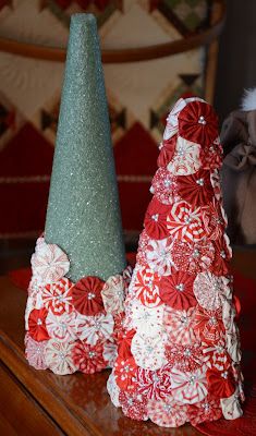 two small christmas trees sitting on top of a wooden table