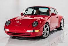 a red sports car parked in a white room