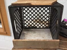 an old wooden crate sitting on top of a table next to a wall and window