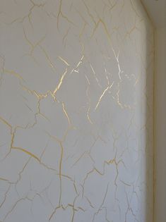 a white wall with gold paint on it