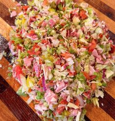 a wooden cutting board topped with lots of chopped up veggies on top of it