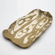 a brown and white ceramic dish sitting on top of a table