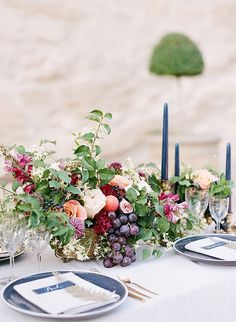 the table is set with flowers and candles