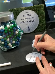 a person is holding a pencil and writing on a piece of paper next to some golf balls