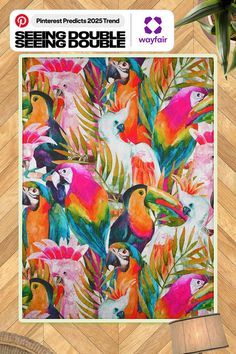 a poster with colorful birds and palm leaves on it's side, next to a wicker chair