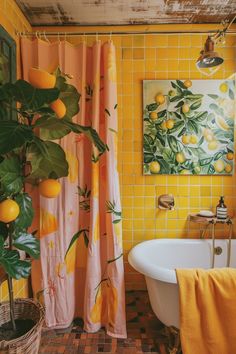 a bathroom decorated in yellow and pink with oranges on the shower curtain next to a bathtub