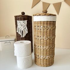 two wicker containers and one roll of toilet paper