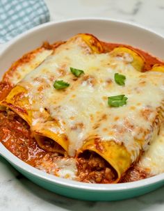 a white bowl filled with lasagna sauce and cheese