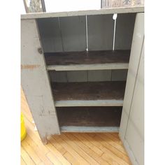 an empty shelf in the corner of a room with wood flooring and white walls