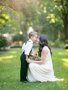 a bride and groom kissing in the grass