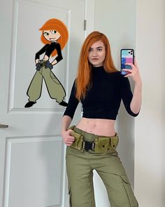 a woman with red hair holding up a cell phone in front of a cartoon character