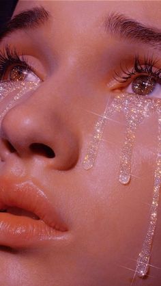 a close up of a woman's face with water dripping from her eyes and eyelashes