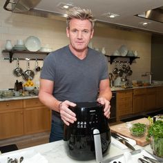 a man standing in front of a large pot on top of a kitchen counter with utensils