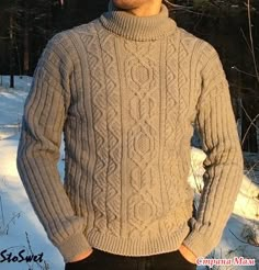 a man standing in the snow wearing a sweater