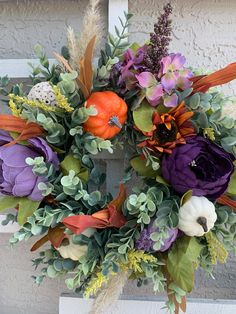 a wreath with purple, orange and green flowers