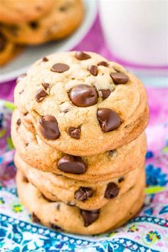 a stack of chocolate chip cookies sitting on top of a blue and white table cloth