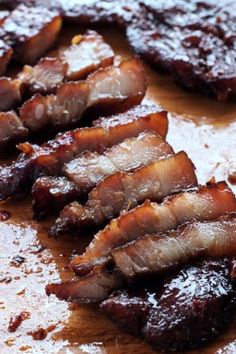 sliced up meat sitting on top of a wooden cutting board