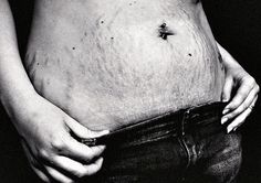 a black and white photo of a woman's stomach