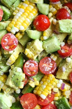 a salad with tomatoes, corn and avocado