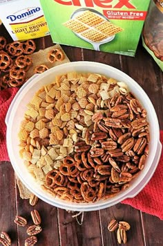 a bowl filled with cereal and nuts next to a carton of chex