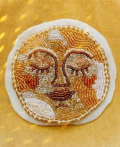 a close up of a small patch with a face made out of beaded material