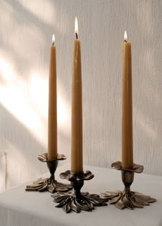 three candles sitting on top of a table next to each other