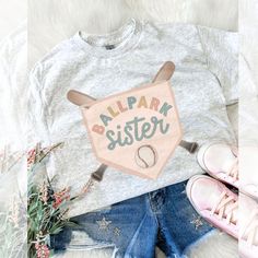 an image of a tee shirt with the words alpark sister on it next to shoes and flowers