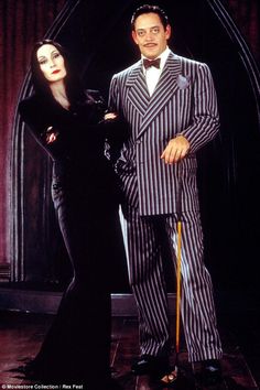 a man and woman dressed up in halloween costumes, standing next to each other on stage