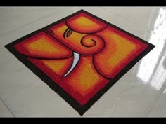 a painting on the floor with an orange and black square in front of it that has a knife sticking out of it