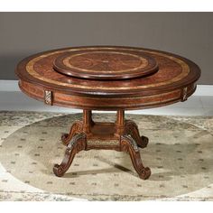 a round wooden table sitting on top of a rug