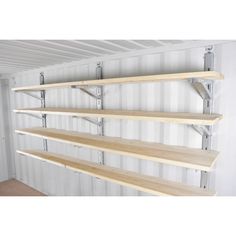 three wooden shelves with metal brackets on the sides and one shelf above them, in a room