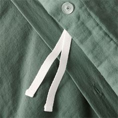 a piece of white thread is on the green shirt