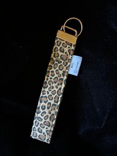 an animal print case with a tag on the front and side of it, sitting on a black surface