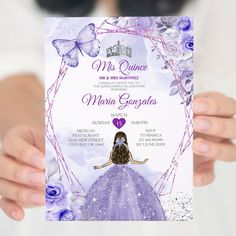 a woman holding up a purple and white princess themed wedding card with butterflies on it