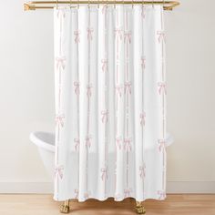 a white shower curtain with pink bows on it and a bathtub in the background