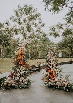 an outdoor ceremony setup with flowers and greenery