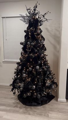 a black christmas tree with silver ornaments