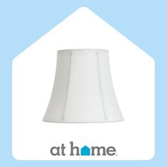 a white lamp shade sitting on top of a blue and white house with the words at home above it