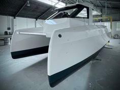 a white and black boat in a warehouse with no people on it's sides