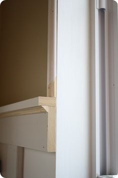 the corner of a room with a door and window sill in front of it