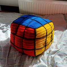 a knitted cube sitting on top of a bed