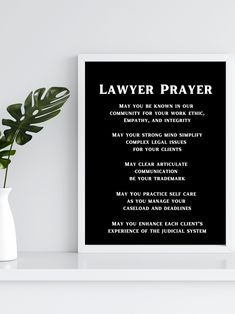 a black and white poster with the words'lawyer prayer'next to a potted plant