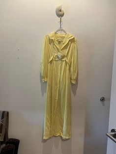 "Estate sale find. Very pretty nylon Dutchess Individually Yours yellow maxi dress.   It's a classic 1970's maxi dress with an attached sash with white rose detail that ties at back.  The vanity size label is a Small and would fit a size an x-small/ small best today.  Please review video, pixs, and measurements below.  All sales final. PTP 17\" STH 49\" *This is a vintage item which has history and was pre-loved. All major flaws are listed, but small blemishes like loose stitches and buttons may Yellow Maxi Dress, Yellow Maxi, Boho Cottagecore, Belt Tie, Rosé Details, Estate Sale Finds, Size Label, White Rose, Dress Clothes For Women