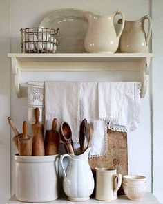 white dishes and utensils are sitting on a shelf