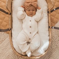 a baby is laying down in a wicker basket